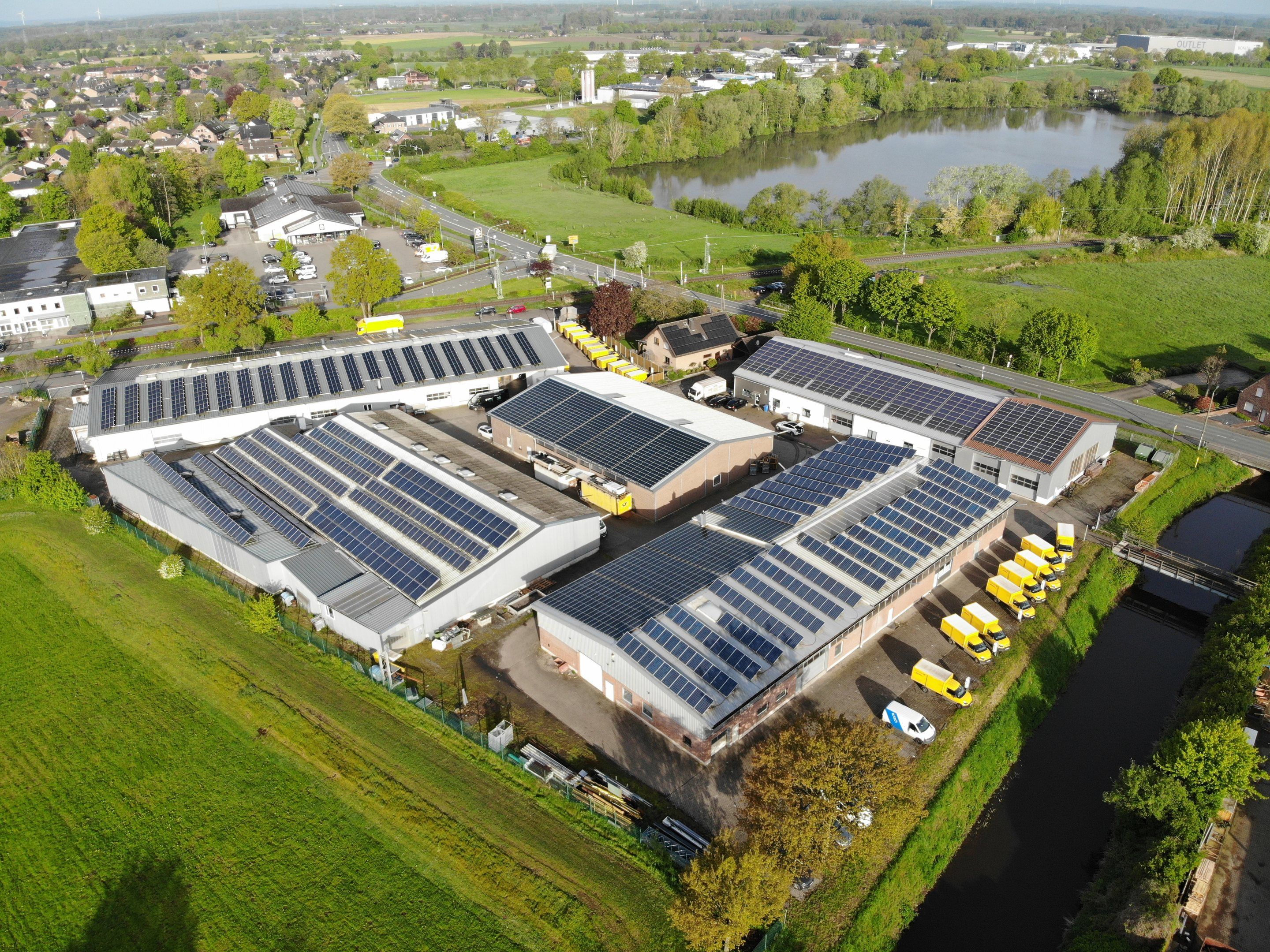 Luftbild des Business Parks Industriestraße mit Hallen am Wasser und Blick über Hamminkeln