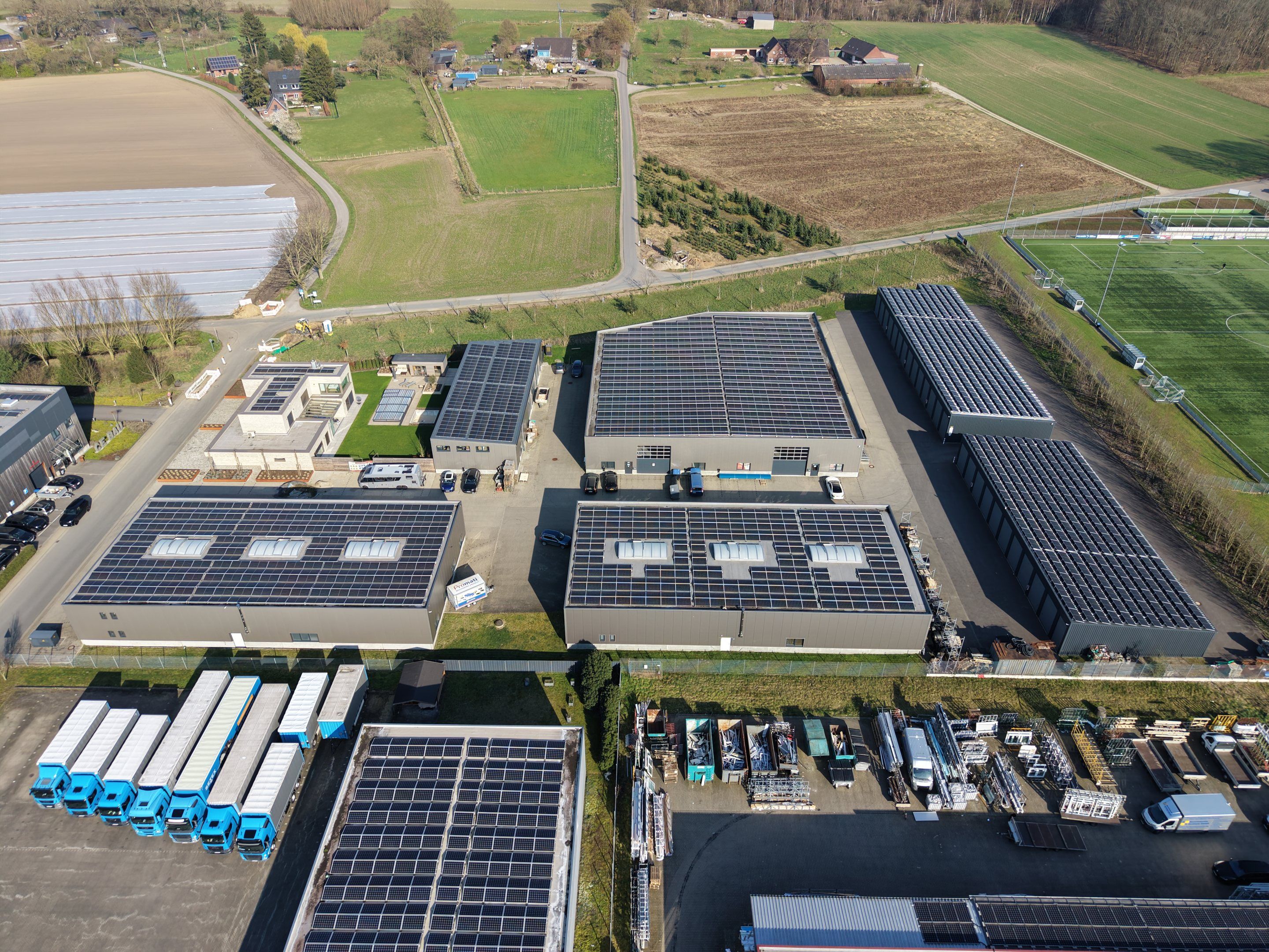 Luftbild des Business Parks Uhlandsweg mit Hallen und Solardächern zwischen Feldern